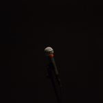 Microphone in the spotlight of dark stage. Used under license.
